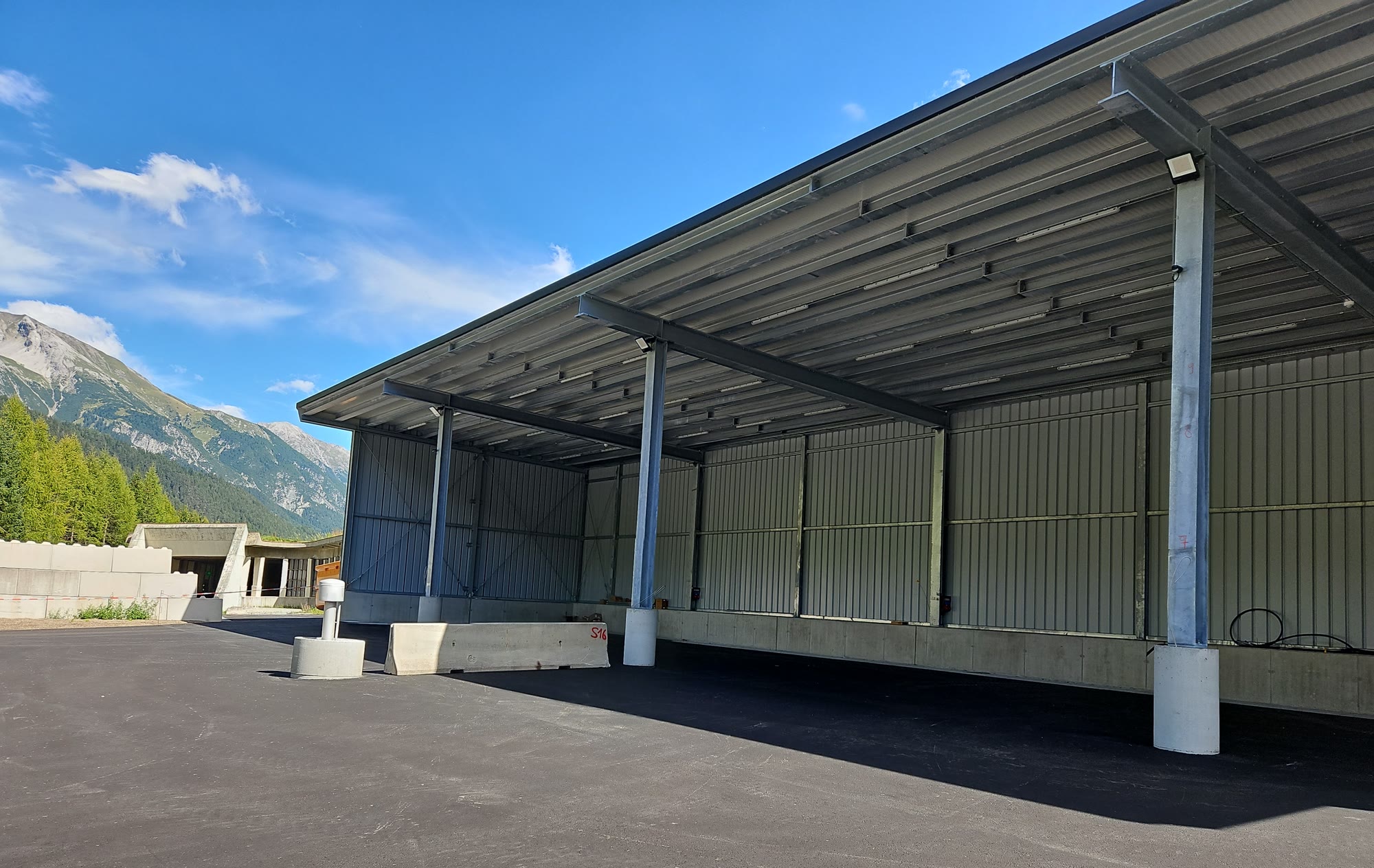 Stahlhalle mit überdachter Ladezone und frisch asphaltierter Fläche